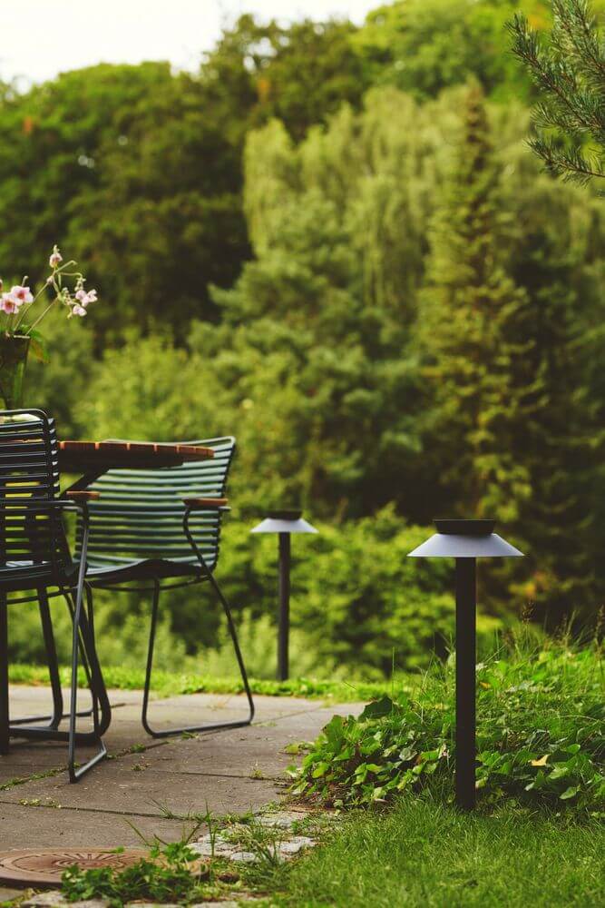 LED Pollerleuchte Justina Solar IP44 beleuchtet einen Gartenweg mit elegantem Design.