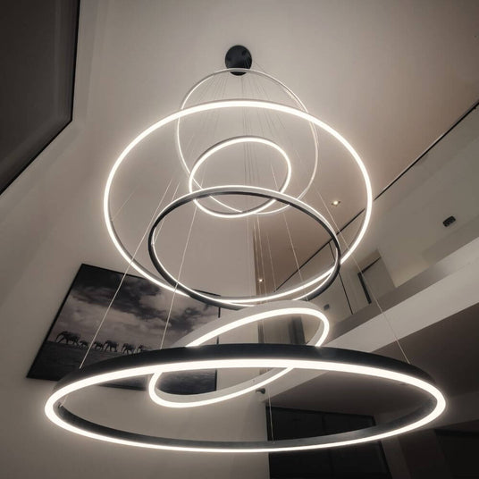 Moderne Hängeleuchte mit kreisförmigen LED-Ringen im minimalistischen Wohnbereich.