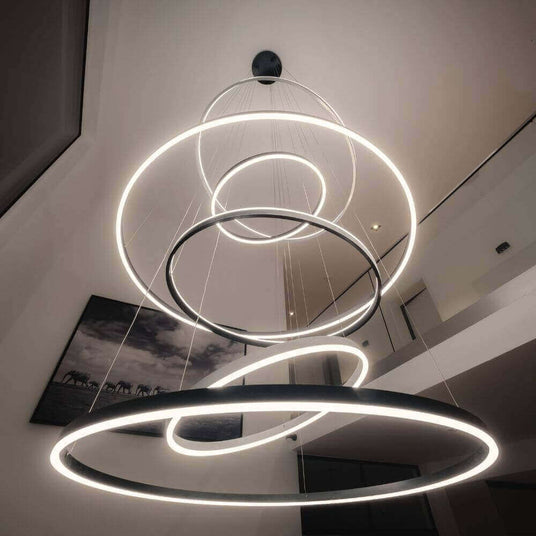 Moderne Hängeleuchte mit kreisförmigen LED-Ringen im minimalistischen Wohnbereich.