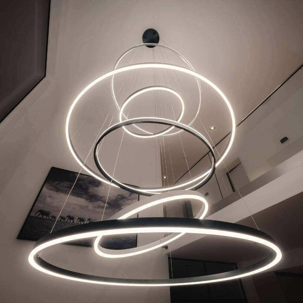 Moderne Hängeleuchte mit kreisförmigen LED-Ringen im minimalistischen Wohnbereich.
