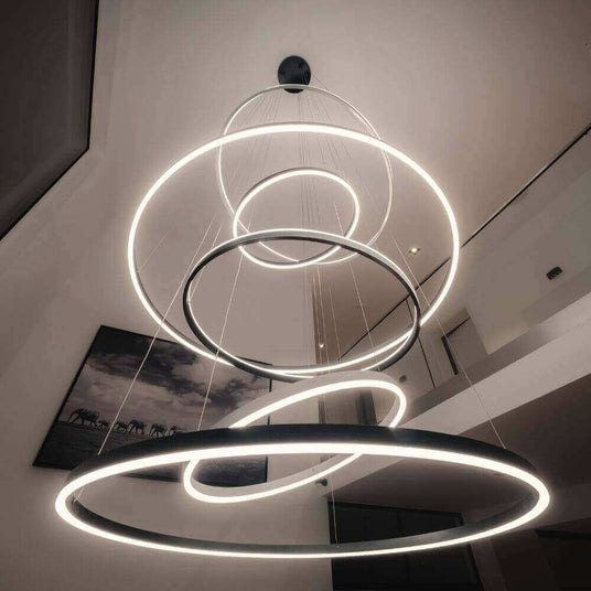 Moderne Hängeleuchte mit kreisförmigen LED-Ringen im minimalistischen Wohnbereich.