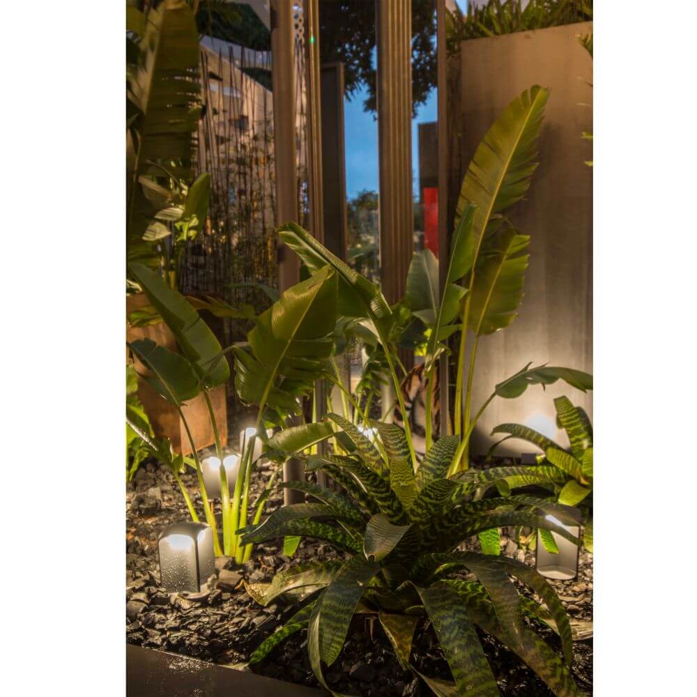 LED Sockelleuchte BU-OH 26cm IP65 Dunkelgrau beleuchtet Pflanzen im Garten.