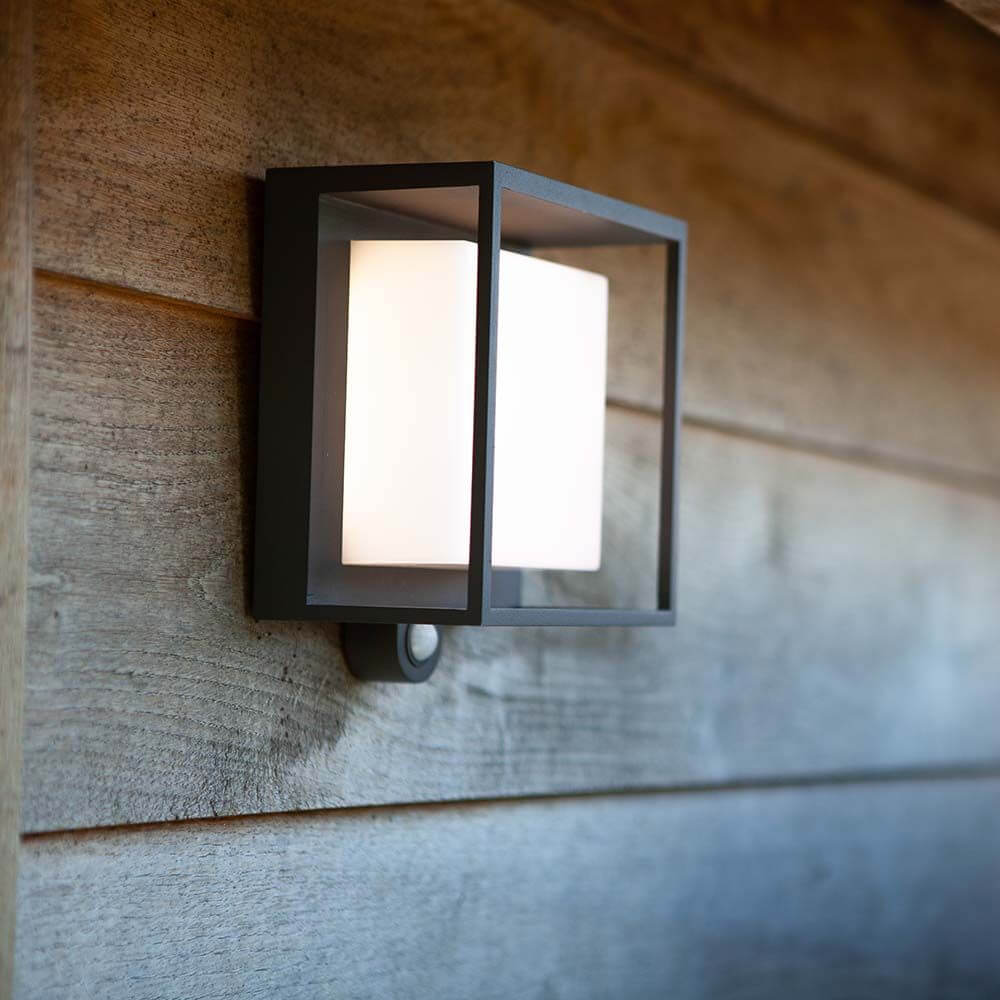 LED-Solar-Außenleuchte Curtis mit Bewegungsmelder an einer Wand montiert.