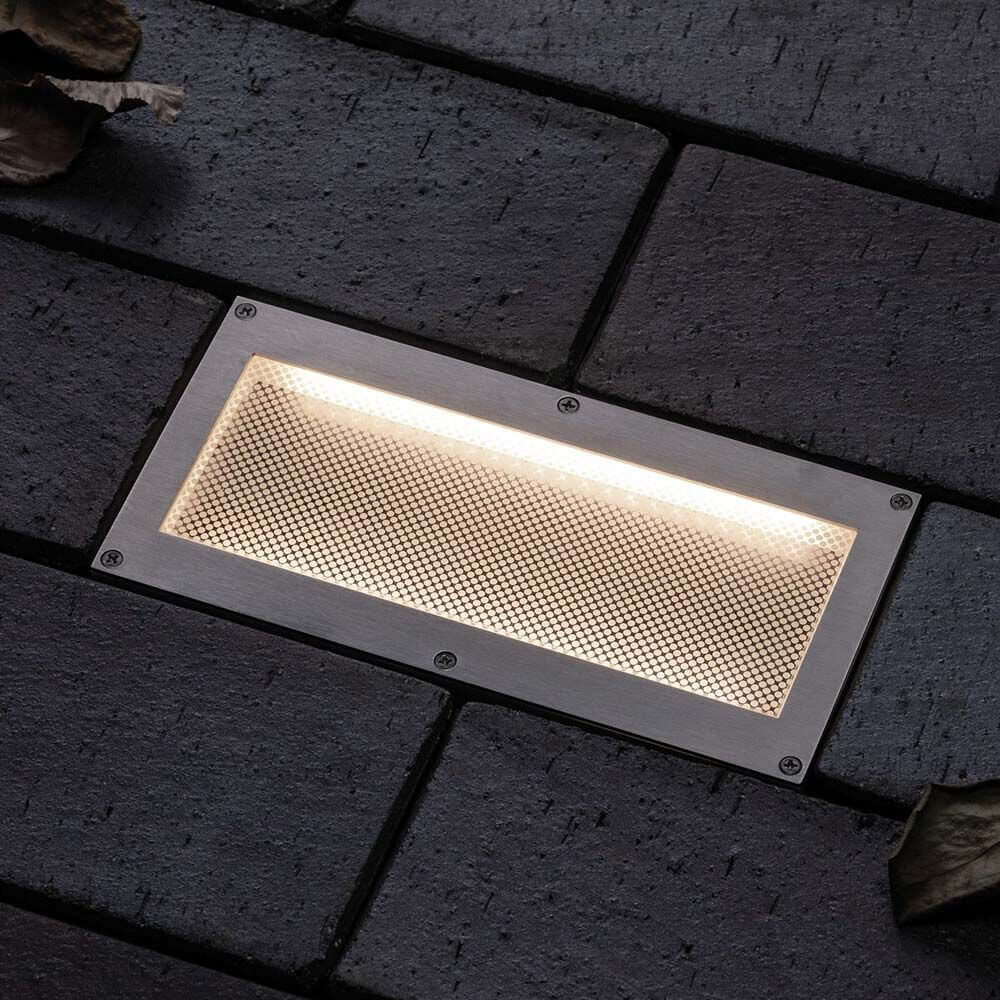 LED Solar Bodeneinbaulampe Aron mit Sensor IP67 3000K in gepflastertem Untergrund, strahlt warmes Licht aus.