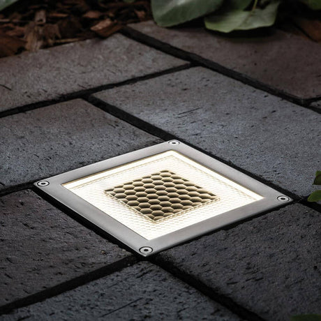LED Solar in-ground floor light Cube IP67 stainless steel on a paved path in the garden.