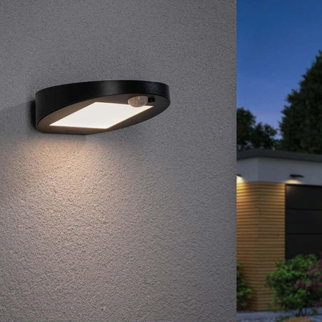 LED Solar Wandleuchte Ryse mit Sensor IP44 3000K Anthrazit an einer Wand montiert, strahlendes Orientierungslicht.