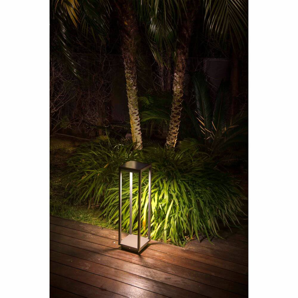 LED Solar Wegeleuchte SAURA mit Bewegungsmelder IP54 Dunkelgrau in einem Garten mit Pflanzenbeleuchtung.