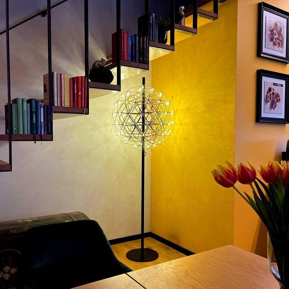 Moderne Stehlampe mit einzigartigem Design, beleuchtet eine gemütliche Ecke in einem stilvollen Raum.