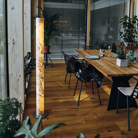 LED-gulvlampe Columna i stein perlehvit i en moderne spisestue med trebord og planter.
