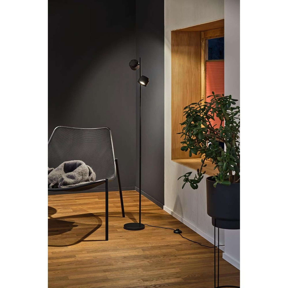 LED Stehleuchte Puric Pane 3 Stufen-Dimmbar Schwarz in modernem Wohnambiente mit Pflanze und Sessel.