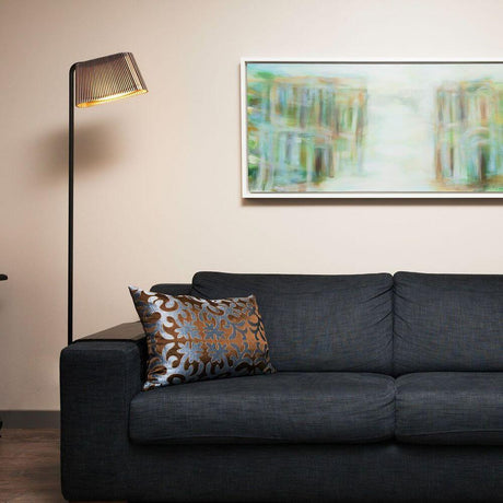 LED Owalo 7010 floor lamps made of wood, 168 cm, next to a sofa in a modern living environment