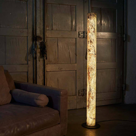 LED Stein-Stehlampe Columna 160cm Bayerischer Herbst leuchtet neben einem Sofa in einem rustikalen Raum.