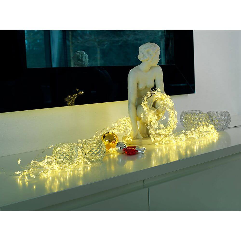 LED Sternenlametta 10 Stränge mit 9 Dioden 90 Warmweiße Dioden dekorativ auf Tisch mit Skulptur und Deko.