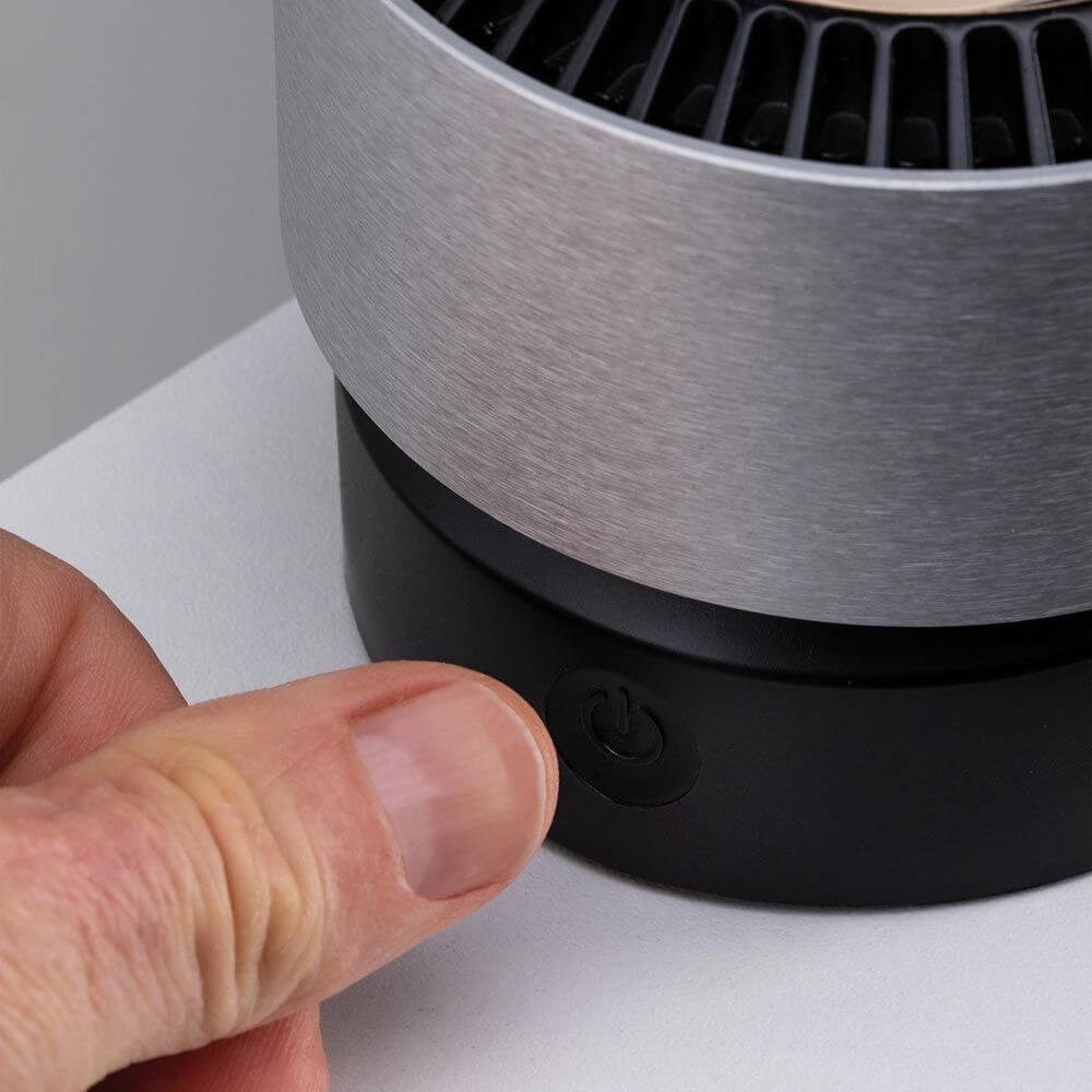 LED Tischleuchte Aldan 3, 5W mit kippbarem Fuß und Touchdimmer, Finger auf dem Ein-/Ausschalter.