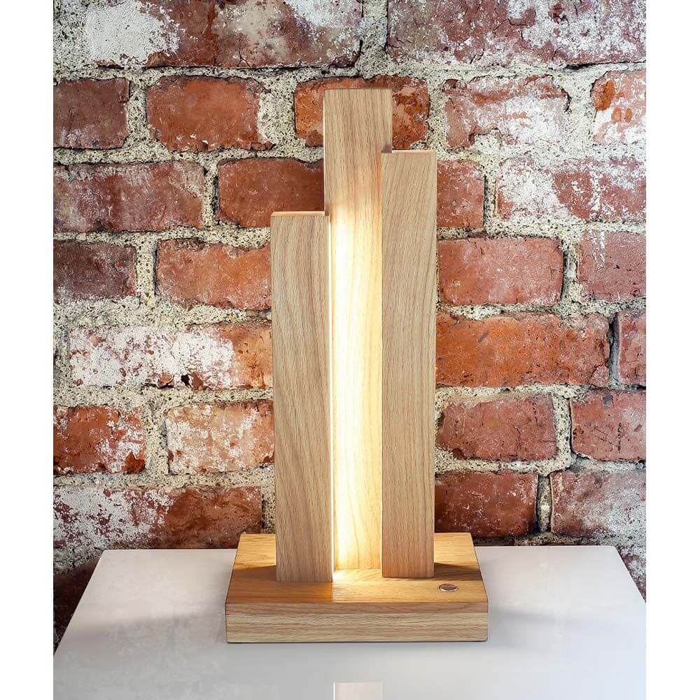 Moderne LED Tischleuchte Manhattan mit Touch-Dimmer aus geölter Eiche, 1470lm, vor Backsteinwand.