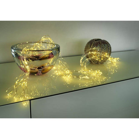 LED Drop tinsel 24 strands with 20 diodes 480 warm white diodes on a table with decoration.