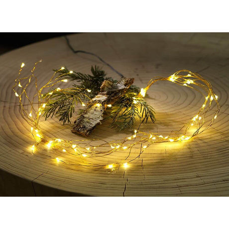 LED Drop tinsel 26 strands with 27 diodes 702 warm white diodes gold-colored wire decorated on a wooden board with branches.