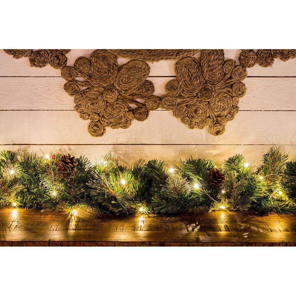 LED Tropfenlichterkette 50 bernsteinfarbene Dioden über einer Dekoration aus Tannenzweigen und Naturmaterialien.