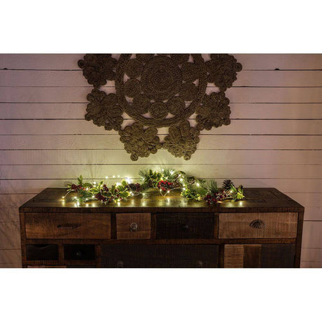LED Tropfenlichterkette 50 Warmweiße Dioden weißer Draht dekoriert auf einem Holztisch mit Naturkranz.
