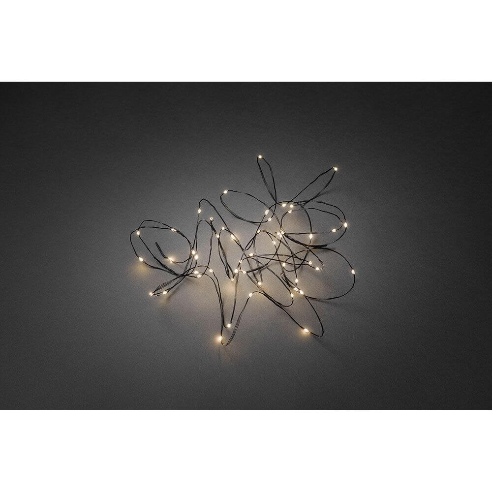 LED Tropfenlichterkette 50 Warmweiße Dioden schwarzer Draht auf dunklem Hintergrund.