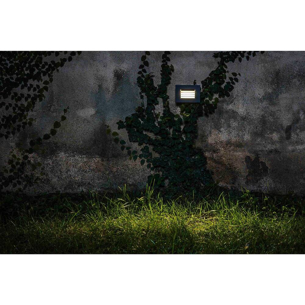 LED Wandeinbauleuchte SPARK-2 3000K IP65 Dunkelgrau an einer Wand mit Pflanzen.