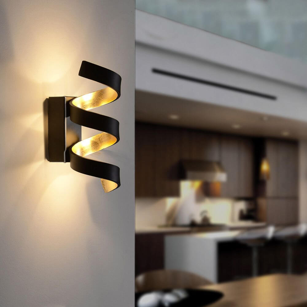 LED Wandlampe Helix Goldfarben, Schwarz an Wand, moderne Beleuchtung für stilvolles Ambiente.