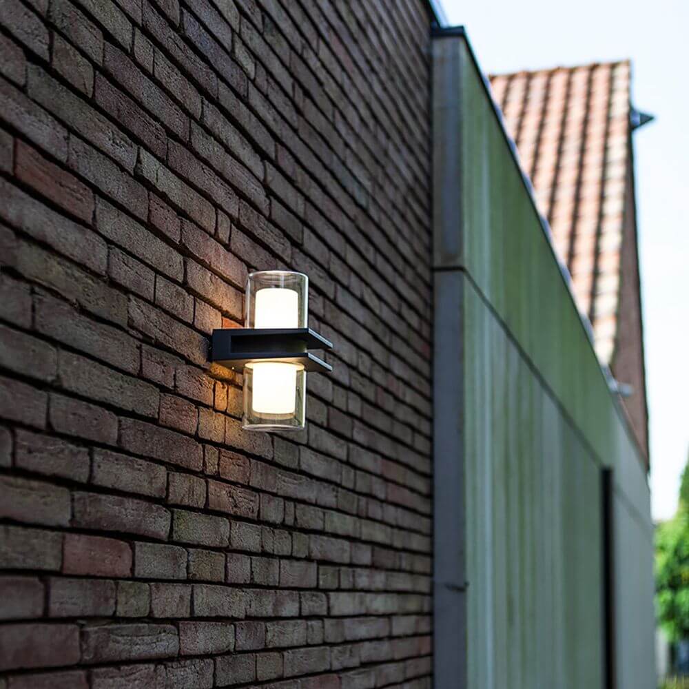 LED Außenwandlampe Tango IP44 Anthrazit an einer gemauerten Wand befestigt, leuchtet nach oben und unten.
