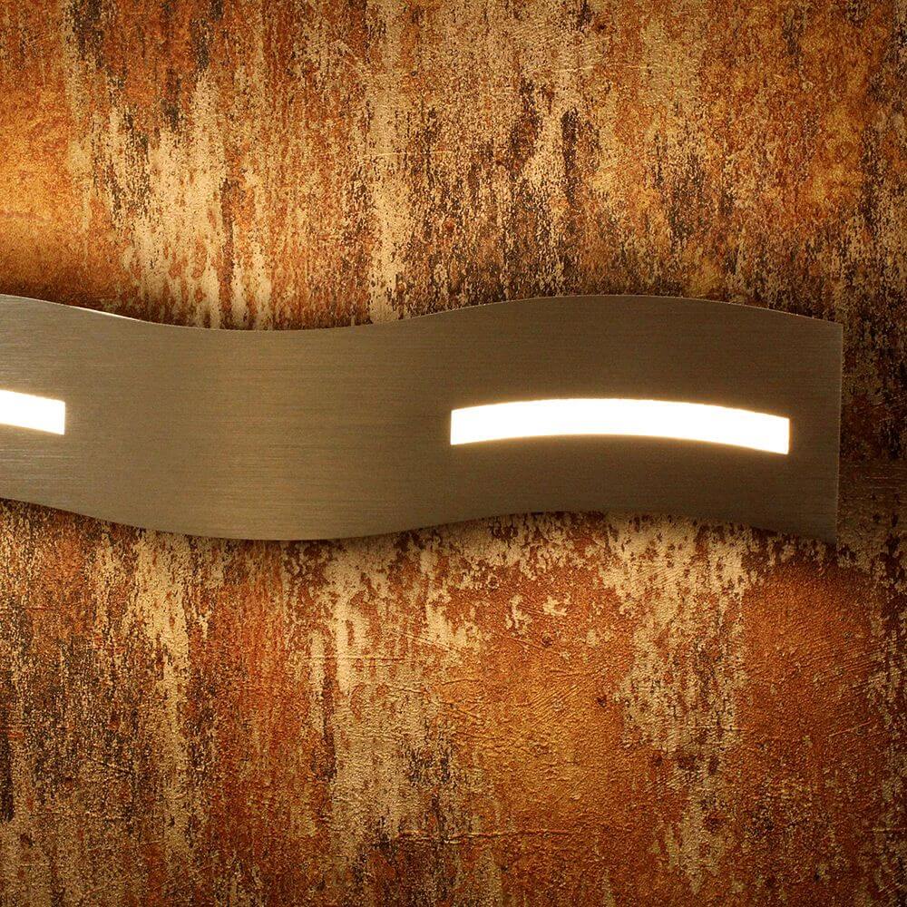 LED Wandlampe Wave Nickel-Matt, Chrom an einer dekorativen Wand aus rostigem, strukturiertem Material.