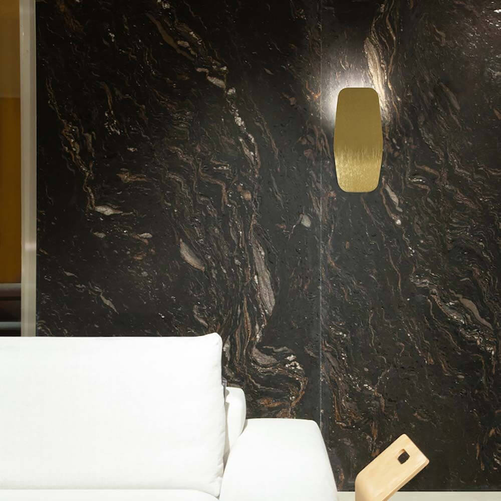 LED-Wandleuchte Ashiya an einer eleganten dunklen Wand mit marmorierter Oberfläche, moderne Ausstattung.