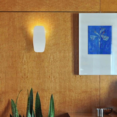 LED-Wandleuchte Ashiya in einem modernen Raum mit Holzvertäfelung und Kunstbild im Hintergrund.