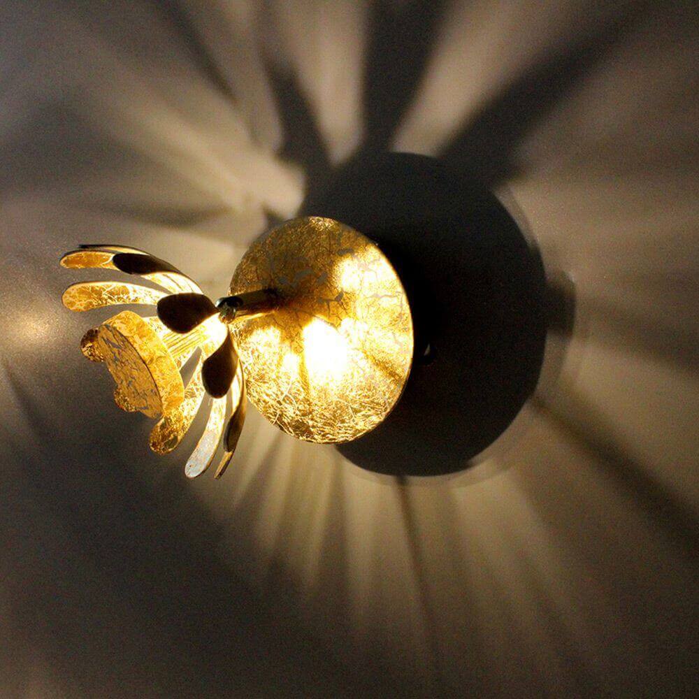 LED Wandleuchte Bloom in Gold, mit blütenförmigem Design und warmweißem Licht, erzeugt schöne Licht-Schatten-Effekte.