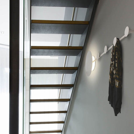 LED Wandleuchte HAN Schwarz Garderobenhaken an einer Wand neben Treppe mit Schal aufgehängt.