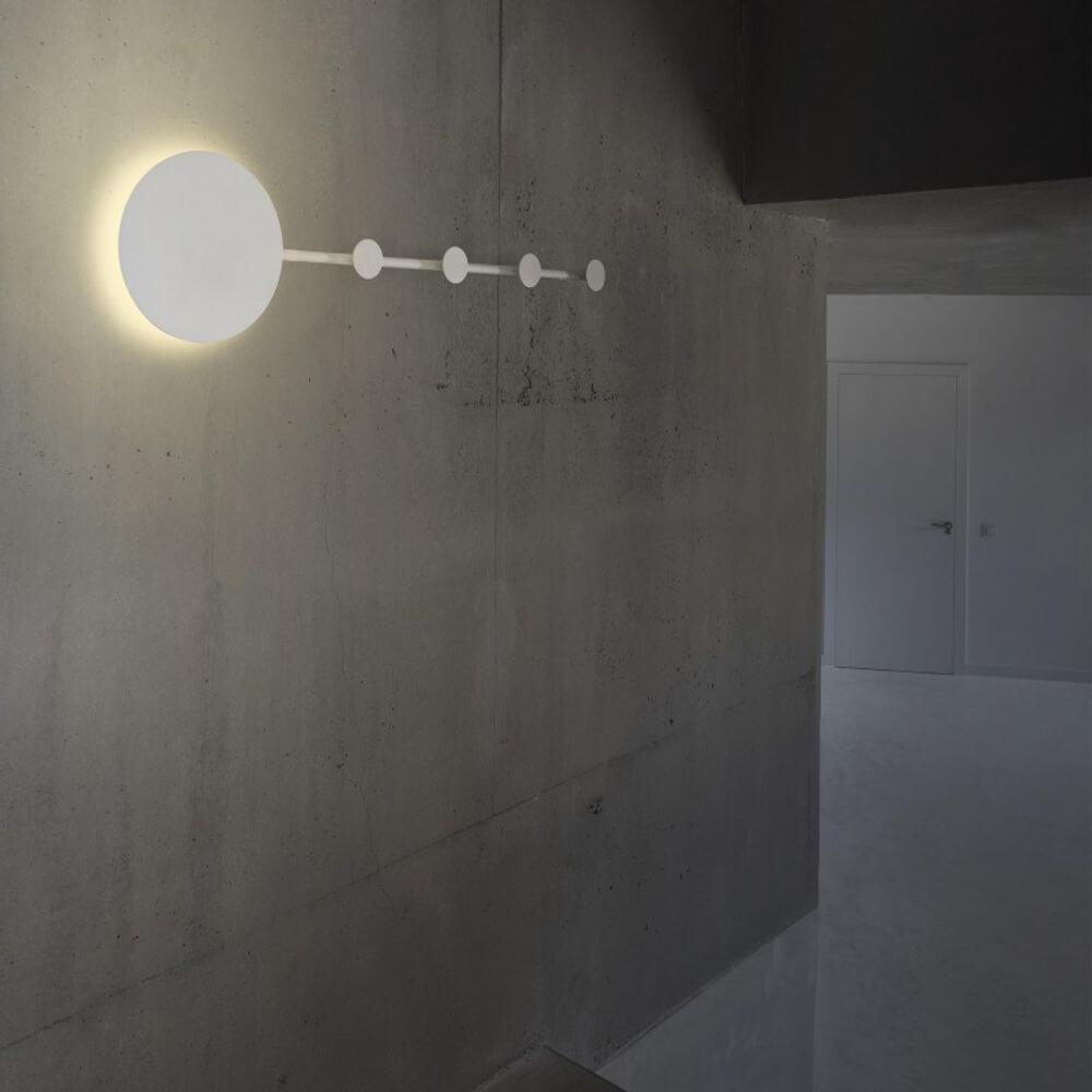 LED Wandleuchte HAN Schwarz Garderobenhaken an einer Betonwand montiert mit warmem Licht.
