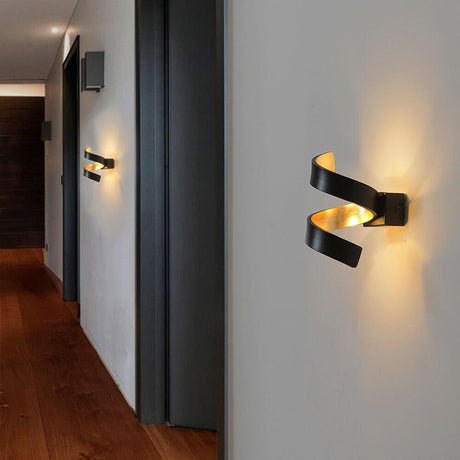 LED Wandleuchte Helix Goldfarben, Schwarz an einer Wand im modernen Innenraum
