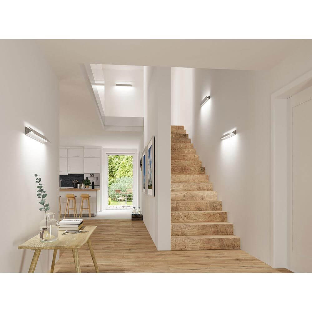 LED Wandleuchte Katla Metall 60cm im modernen Flur mit Holztreppe und indirekter Beleuchtung.