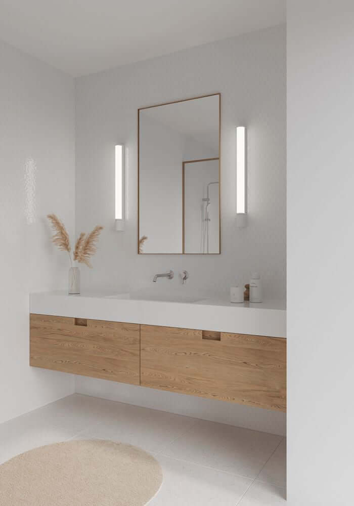 LED Wandleuchte Malaika 68 IP44 neben dem Badezimmerspiegel mit Holzbadmöbeln und Pflanzen.