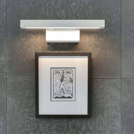LED wall light Smal touch dimmer 490lm white above a framed artwork on a concrete wall.
