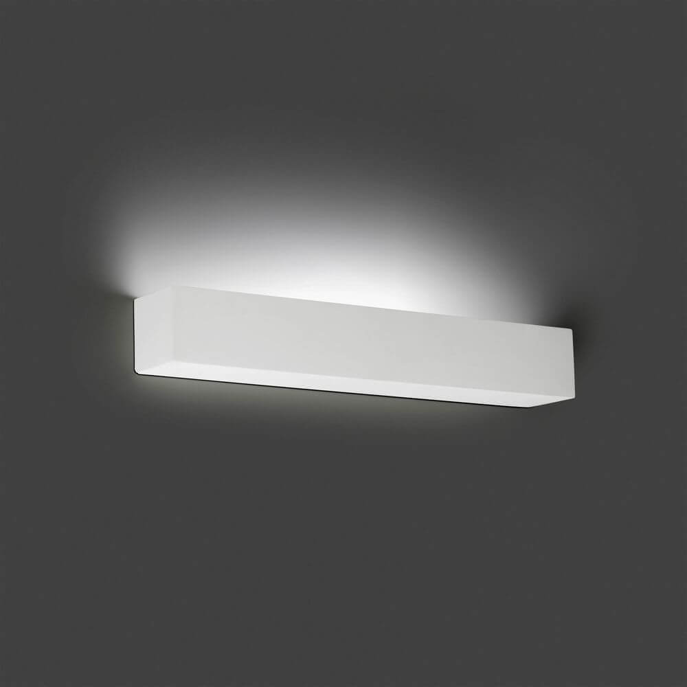LED Wandleuchte TERA Weiß an einer grauen Wand montiert, strahlt sanftes Licht aus.