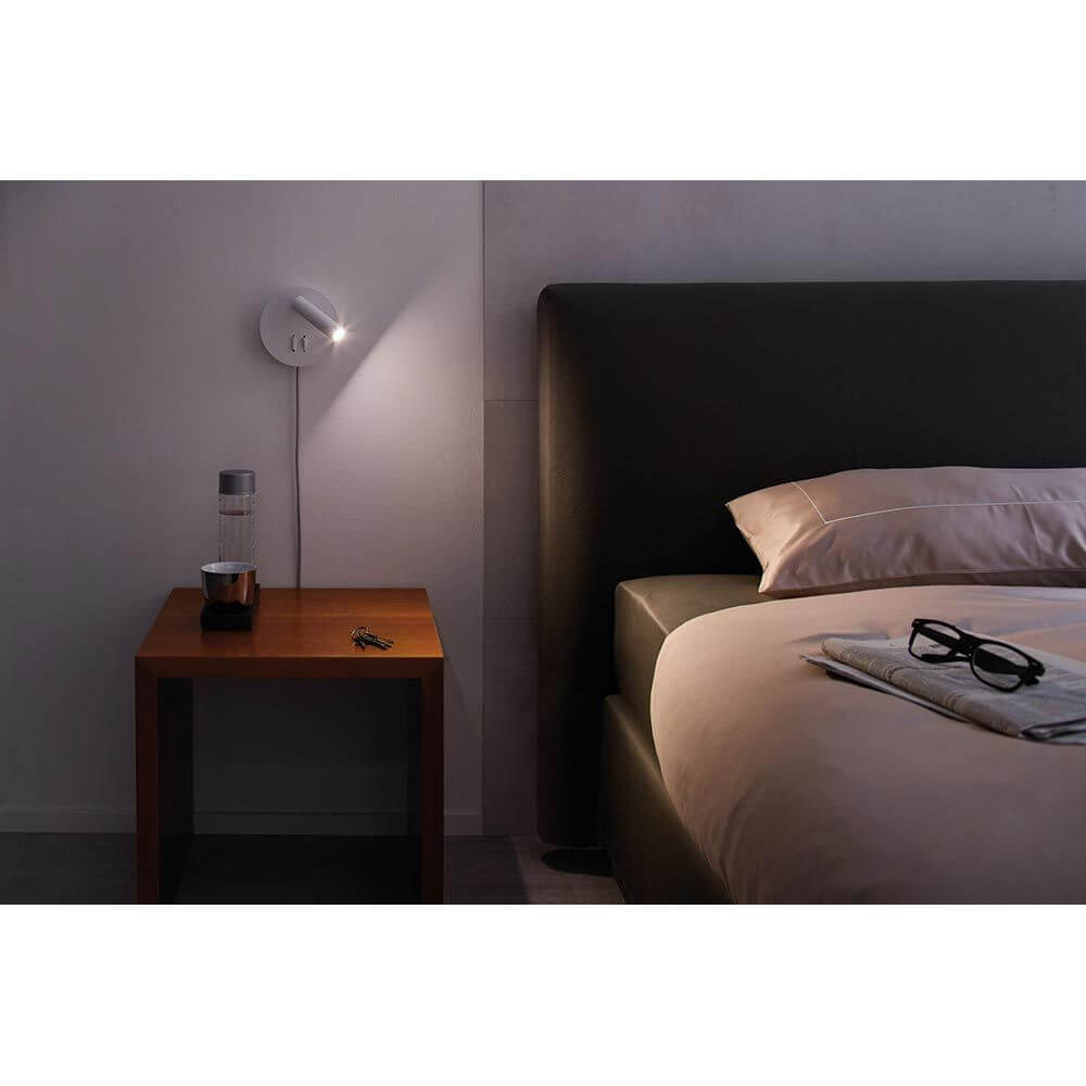 LED Wandleuchte Tabari Weiß, Chrom an einem Bett für indirektes Licht und Lesebeleuchtung.