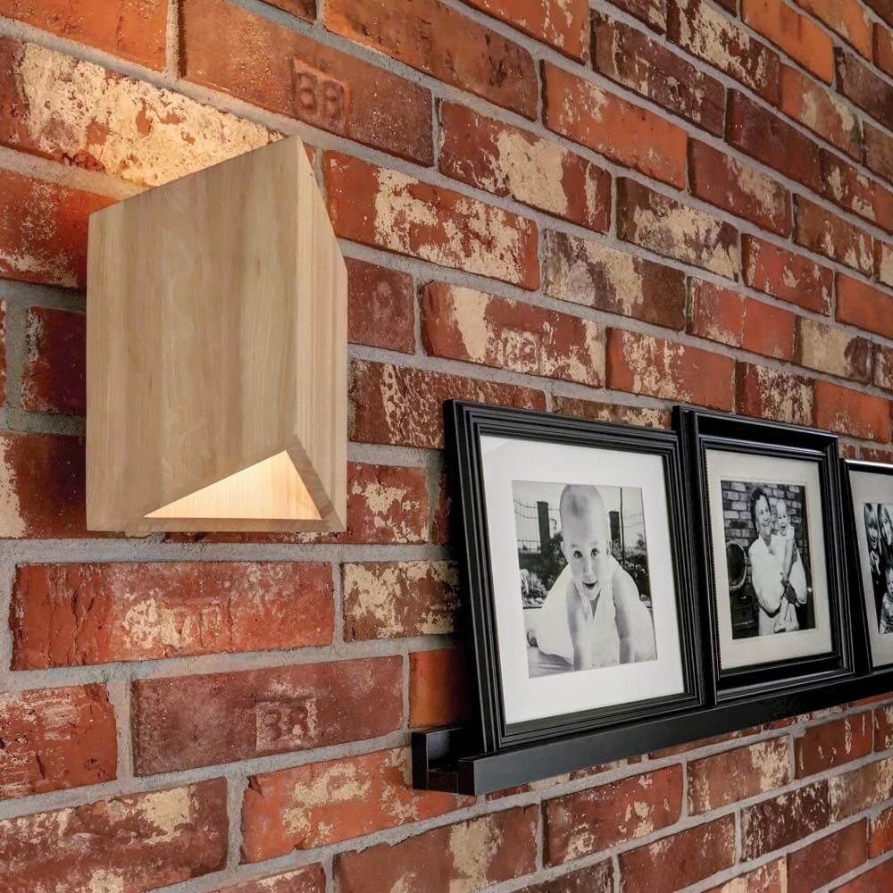 LED Wandleuchte Trekant 720lm Eiche-Geölt an einer Backsteinwand mit Fotos.