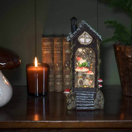 LED Water lantern with battery operation & 5h timer on a table with candle and books in the background.