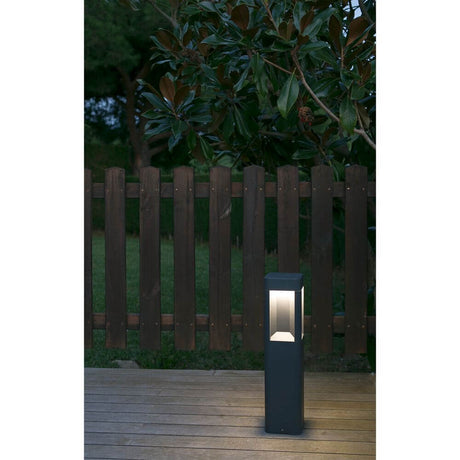 LED Lampe de chemin NAYA 6W 3000K IP54 gris foncé sur une terrasse en bois devant une clôture de jardin.