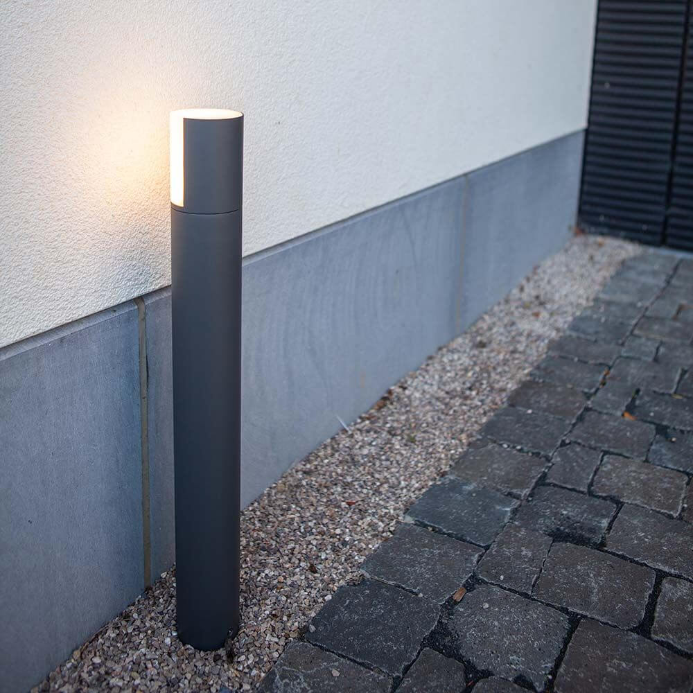 LED-Wegeleuchte Cyra mit drehbarem Kopf steht elegant auf einem Gehweg.