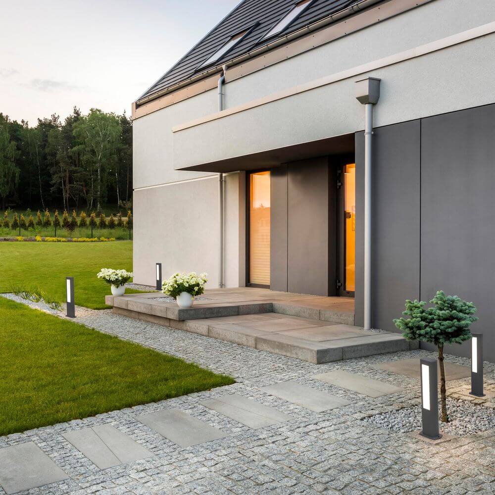 LED Wegeleuchte NANDA 50cm IP54 Dunkelgrau neben einem modernen Eingangsbereich mit Garten.