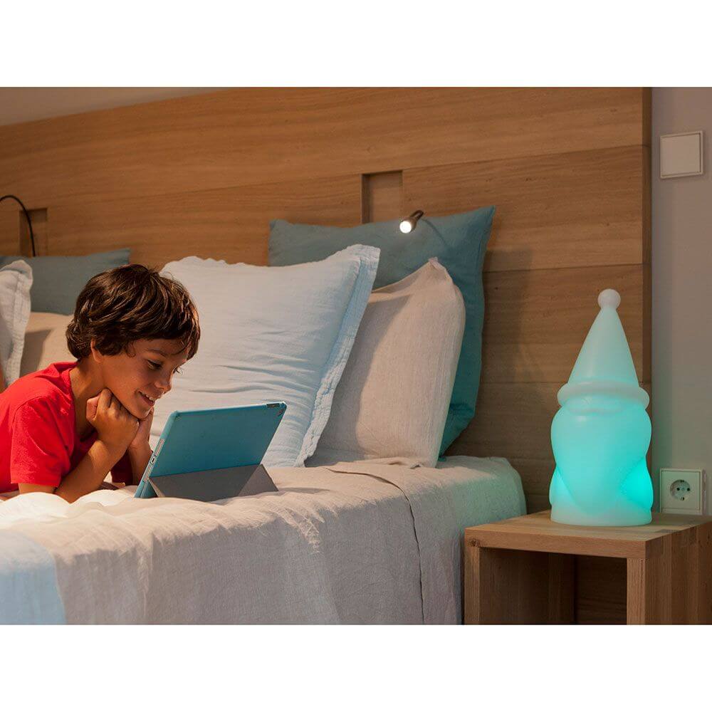LED Weihnachtszwerg Amelio Akku + Solar IP65 leuchtet neben einem Jungen, der entspannt auf sein Tablet schaut.