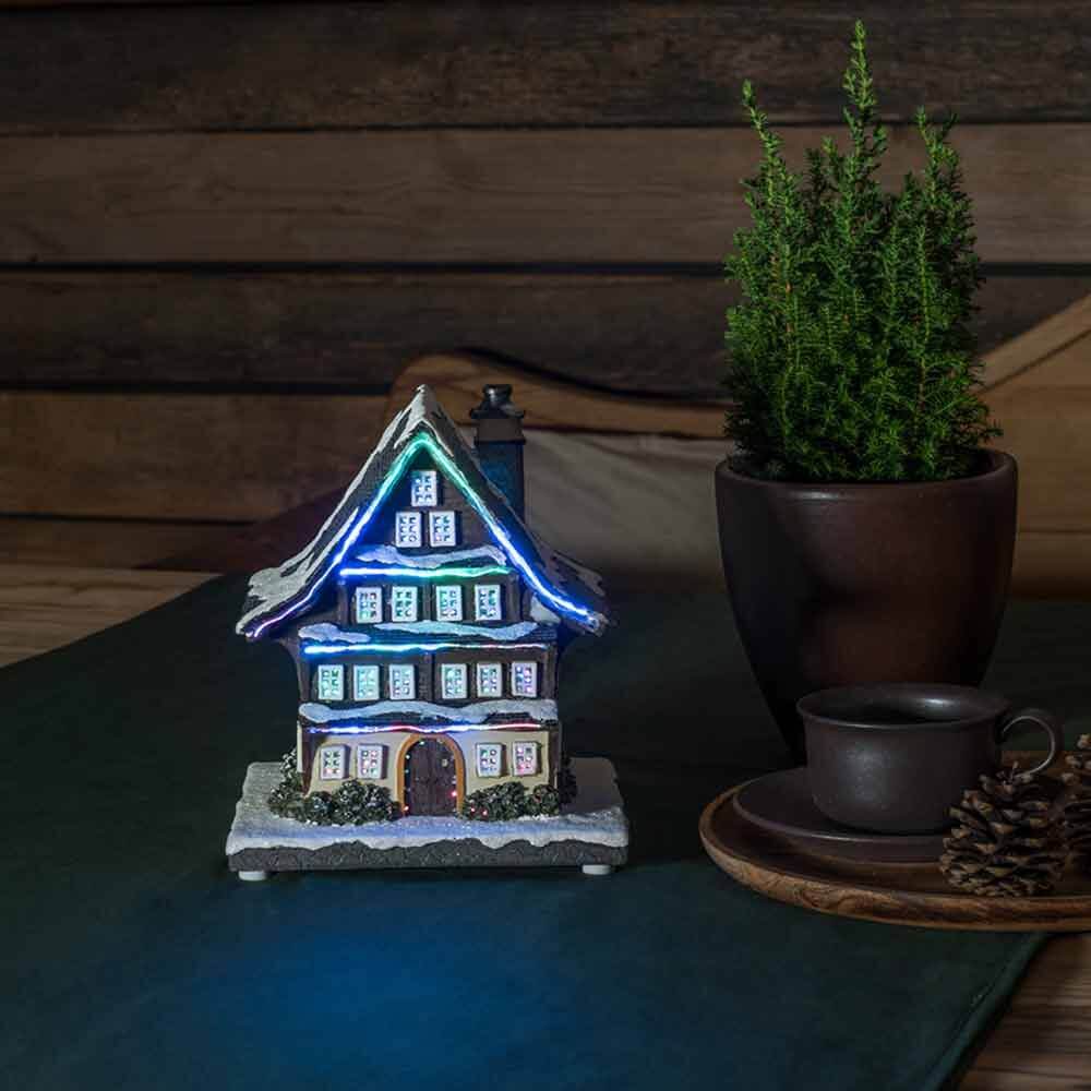 LED Winterhaus batteriebetrieben & 3 mehrfarbigen Leuchtdioden auf einem Tisch mit einer Pflanze und einer Tasse.