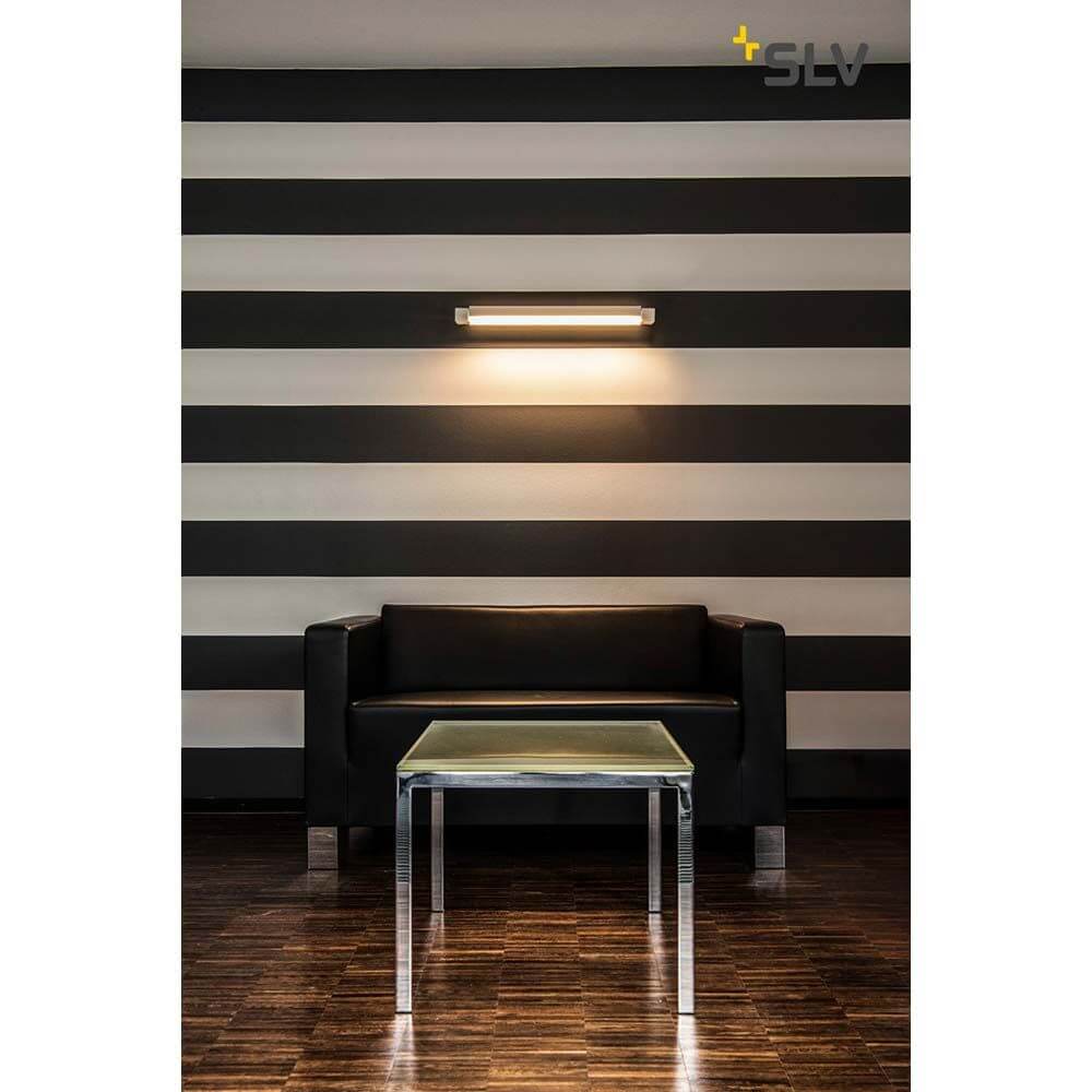 Long Grill LED Wand- und Deckenleuchte Weiß 3000K über schwarzem Sofa in modernem Raum