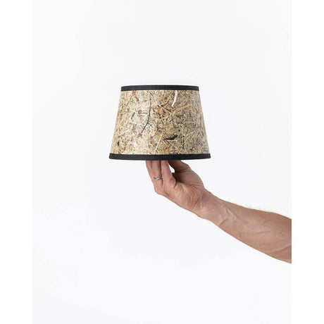 Lampenschirm aus Heu Ø 20cm, konisch, mit schwarzem Baumwollband, in Hand gehalten.