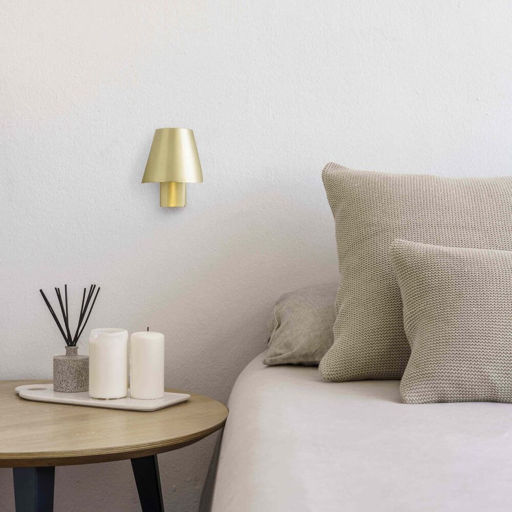 Le Petit LED Wandlampe 3000K an einer modernen Schlafzimmerwand neben einem Beistelltisch.