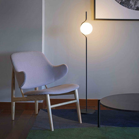 Le Vita LED floor lamp 118 cm with touch dimmer, black, next to a modern armchair and round table.